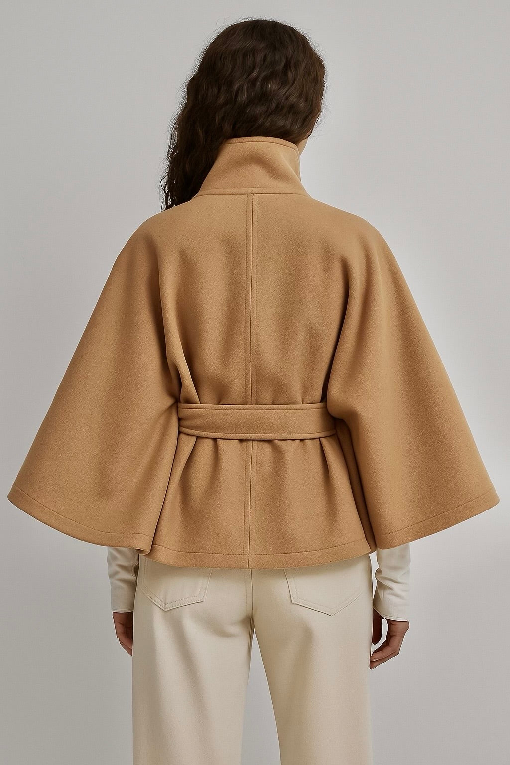 winter coat with high-neck collar, cape silhouette and adjustable waist belt. A chic belted jacket combining elegance, comfort and versatile seasonal style.