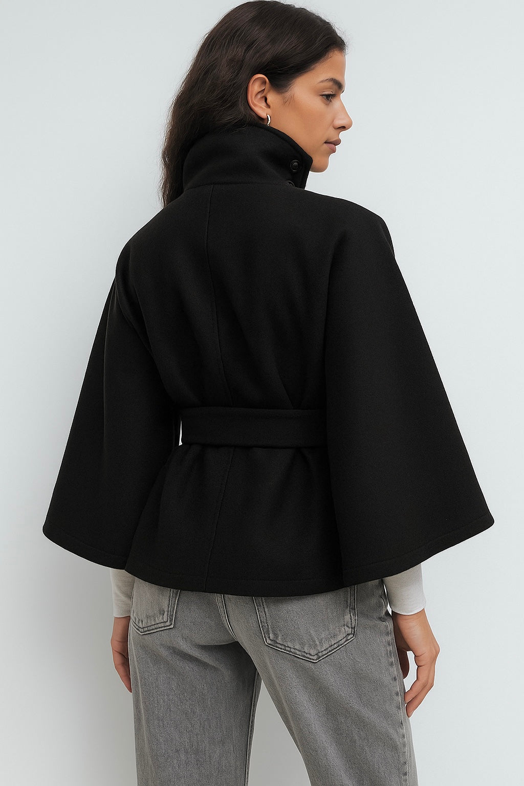 High-Neck Belted Cape Jacket in camel wool blend. Poncho-inspired autumn/winter coat with high-neck collar, cape silhouette and adjustable waist belt. A chic belted jacket combining elegance, comfort and versatile seasonal style.
