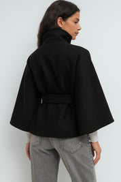 High-Neck Belted Cape Jacket in camel wool blend. Poncho-inspired autumn/winter coat with high-neck collar, cape silhouette and adjustable waist belt. A chic belted jacket combining elegance, comfort and versatile seasonal style.