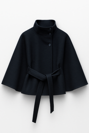 High-Neck Belted Cape Jacket in camel wool blend. Poncho-inspired autumn/winter coat with high-neck collar, cape silhouette and adjustable waist belt. A chic belted jacket combining elegance, comfort and versatile seasonal style.