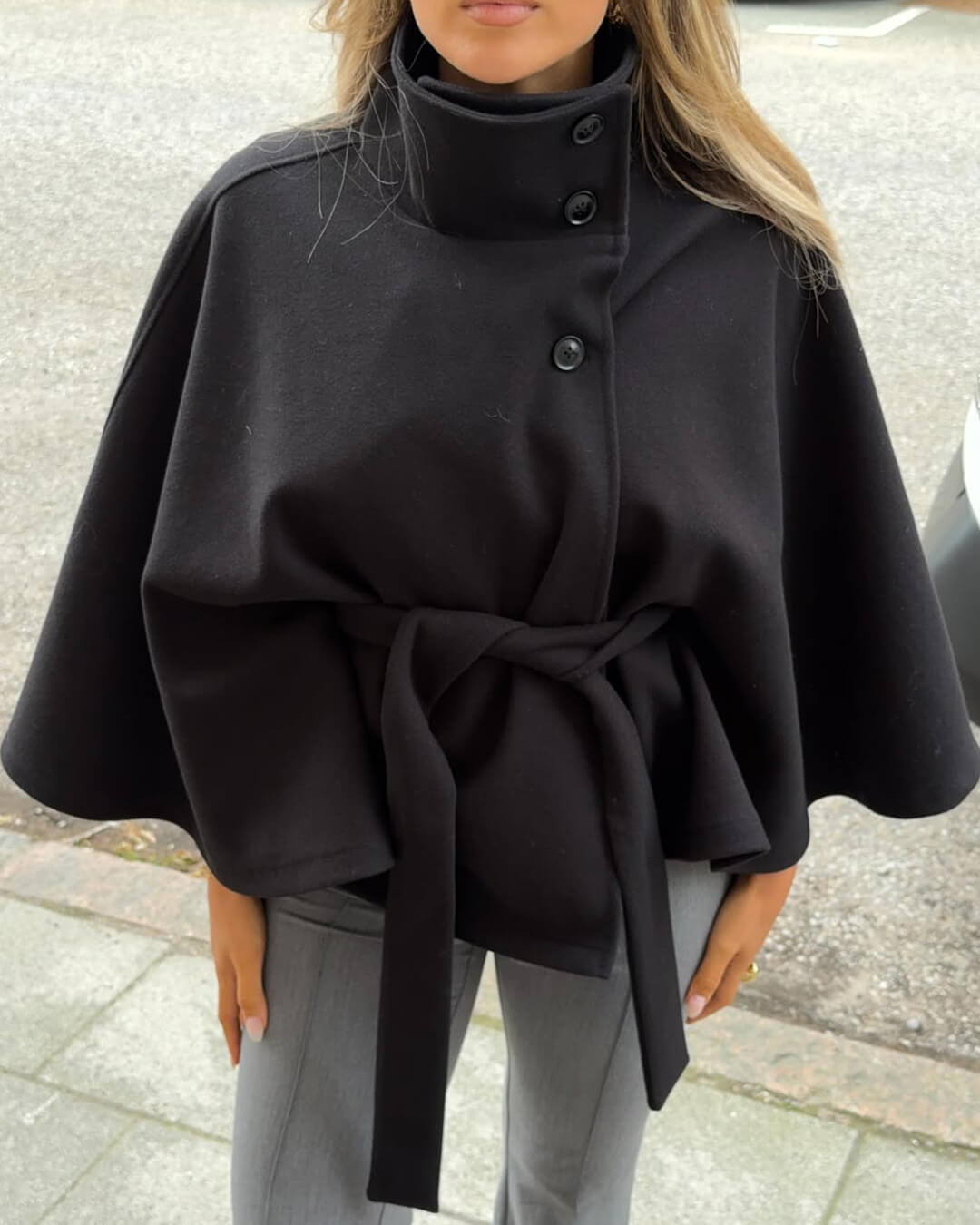 High-Neck Belted Cape Jacket in camel wool blend. Poncho-inspired autumn/winter coat with high-neck collar, cape silhouette and adjustable waist belt. A chic belted jacket combining elegance, comfort and versatile seasonal style.