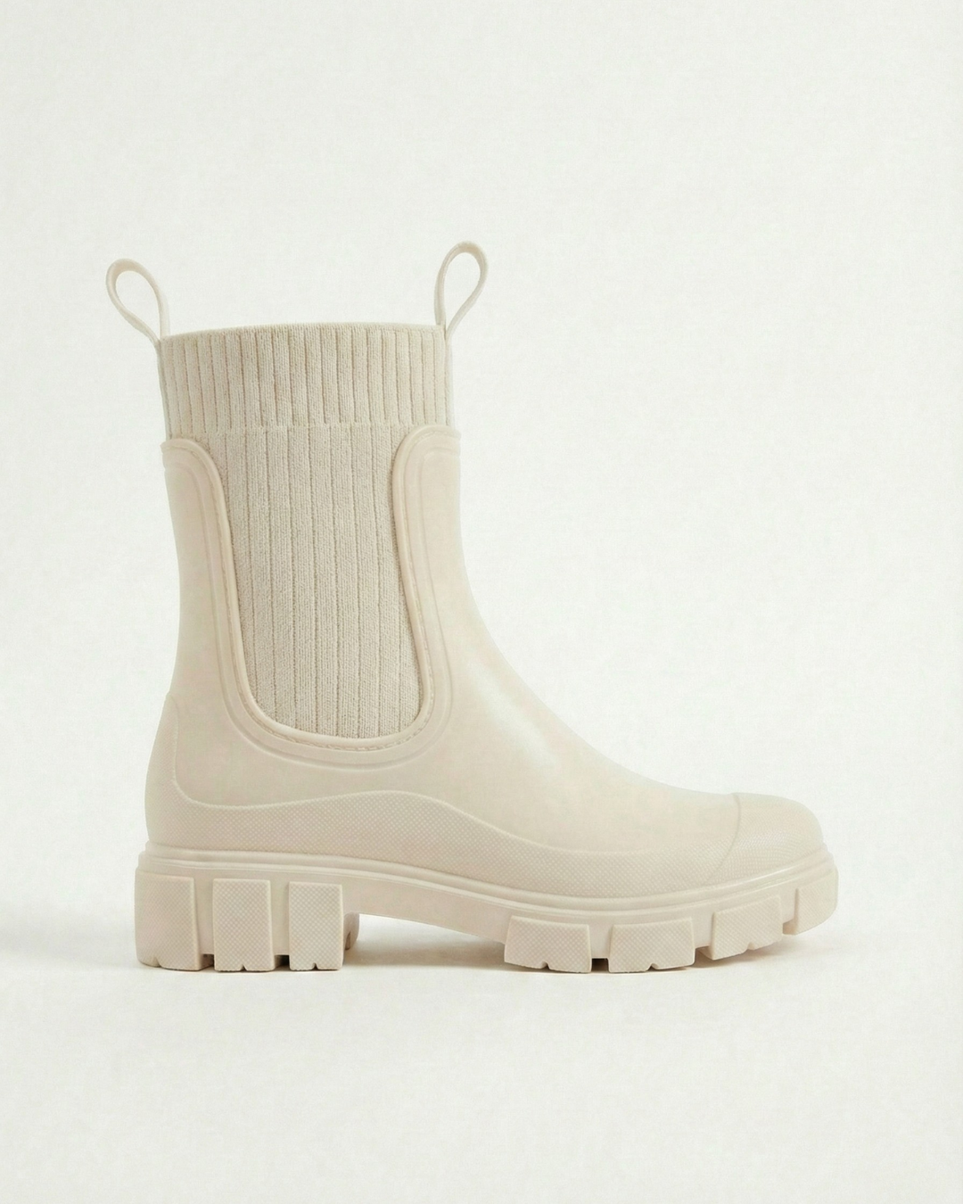 White waterproof ankle boot with elastic side panels, pull tabs and chunky lug sole