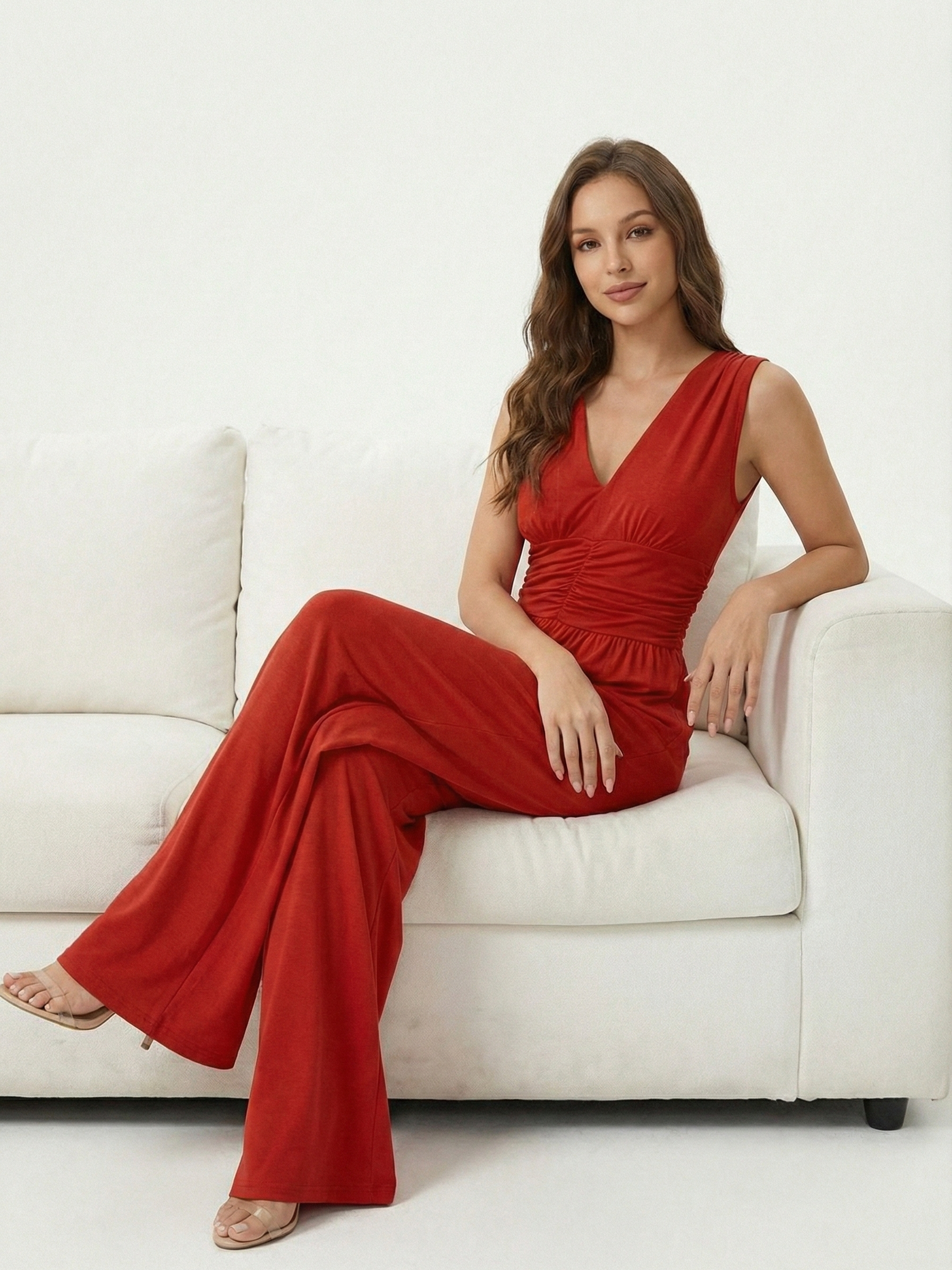 Red sleeveless jumpsuit with deep V neckline, ruched waist and wide-leg trousers