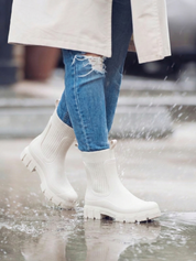 White waterproof ankle boot with elastic side panels, pull tabs and chunky lug sole