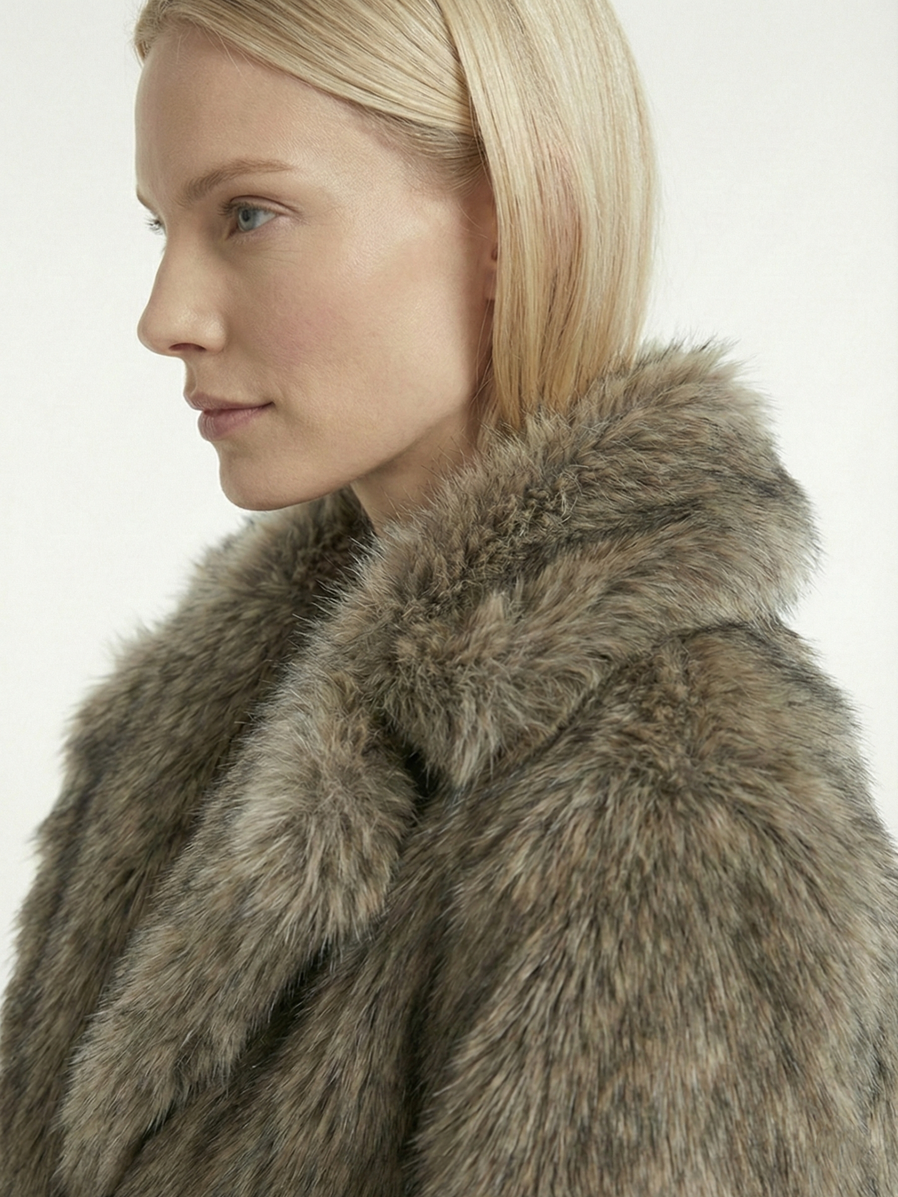 Long faux fur coat in deep brown tones with wide lapel collar and full-length silhouette