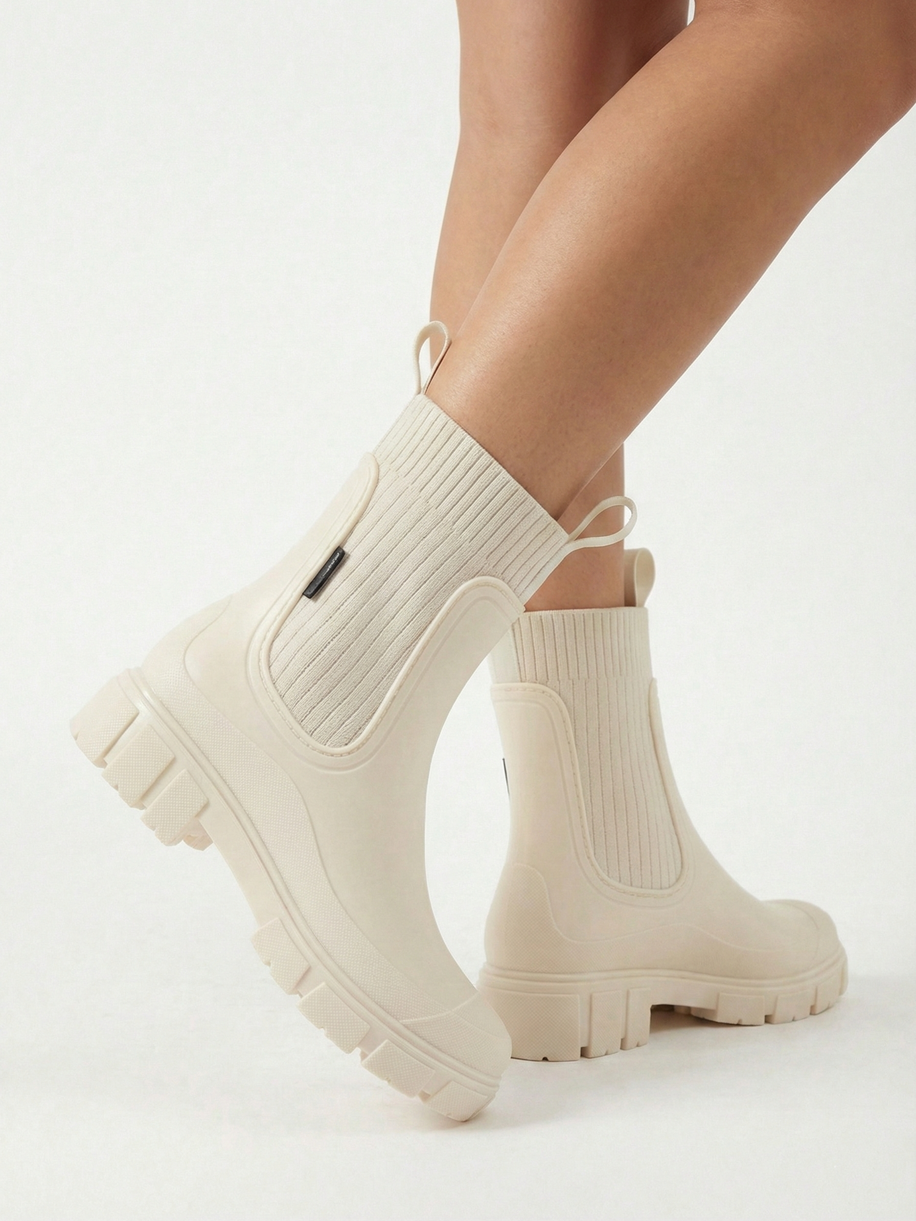 White waterproof ankle boot with elastic side panels, pull tabs and chunky lug sole