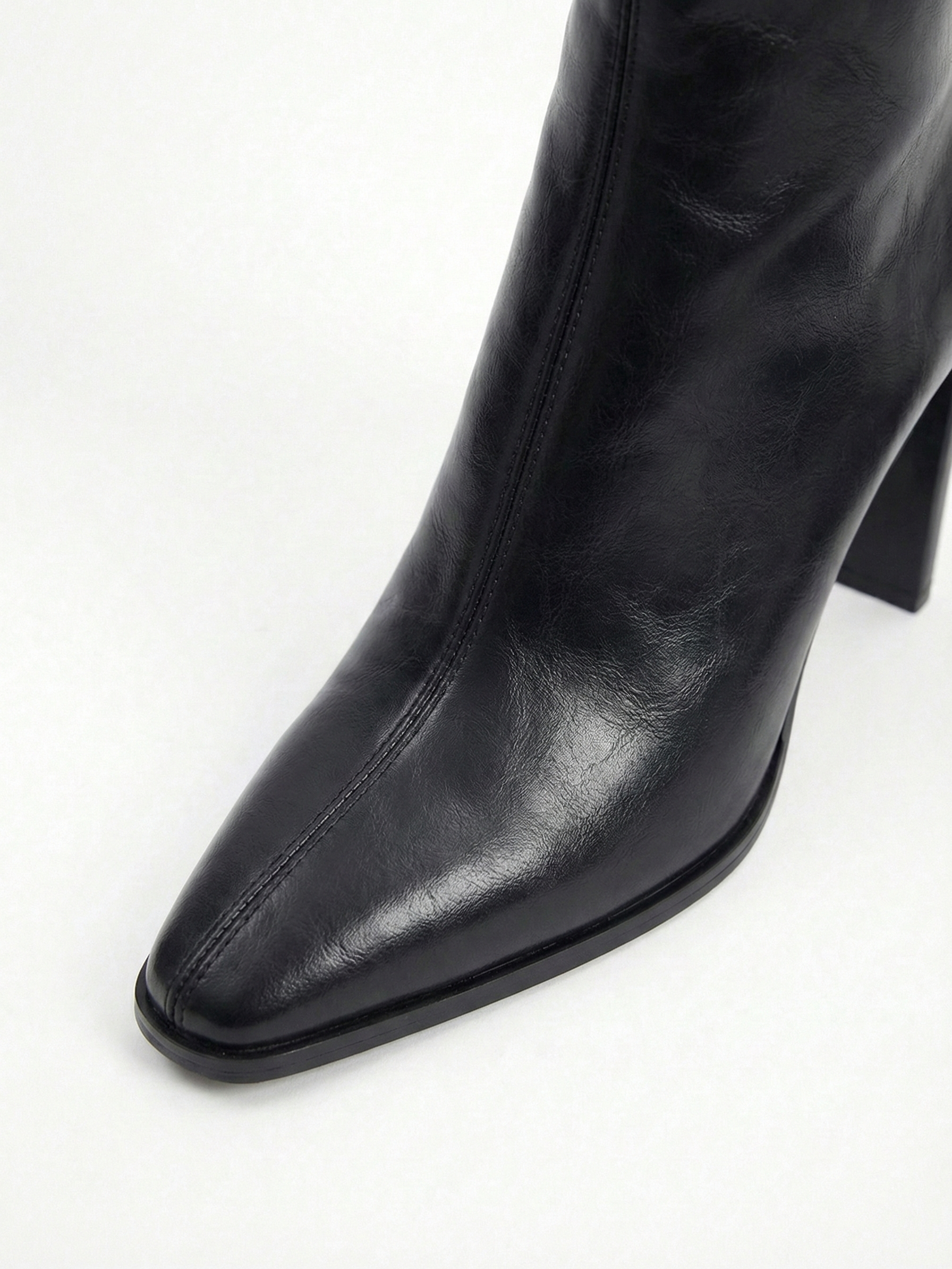 Black high-heel ankle boot with a sleek square toe, smooth leather-look finish, structured shaft, and slim stiletto heel.
