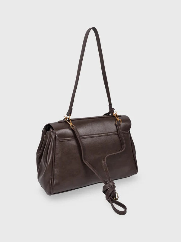 Dark brown leather shoulder bag with structured shape, flap closure and slim top handle, photographed on a light background