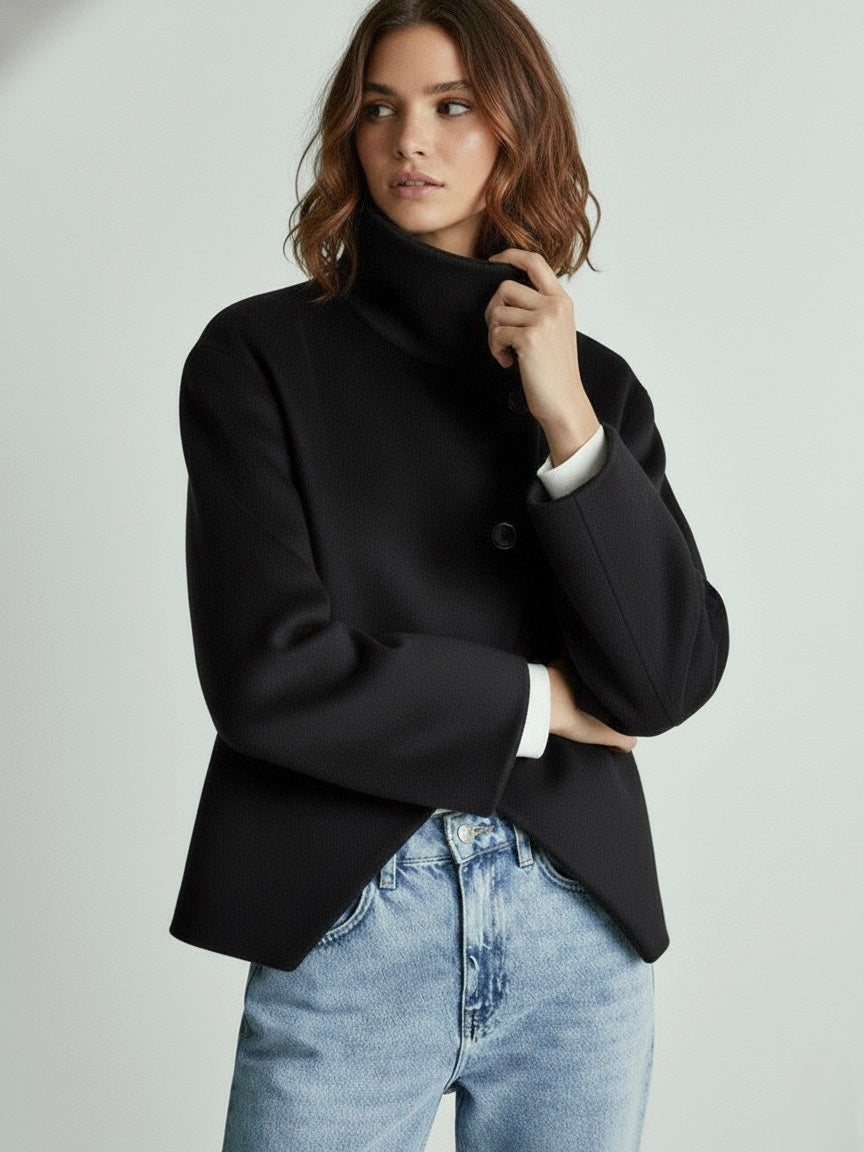 Black high-neck jacket with asymmetrical buttons and structured silhouette, featuring wide sleeves and a minimalist design for modern everyday styling.