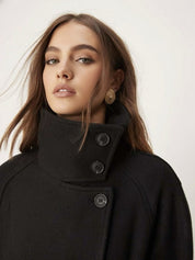 Black high-neck jacket with asymmetrical buttons and structured silhouette, featuring wide sleeves and a minimalist design for modern everyday styling.