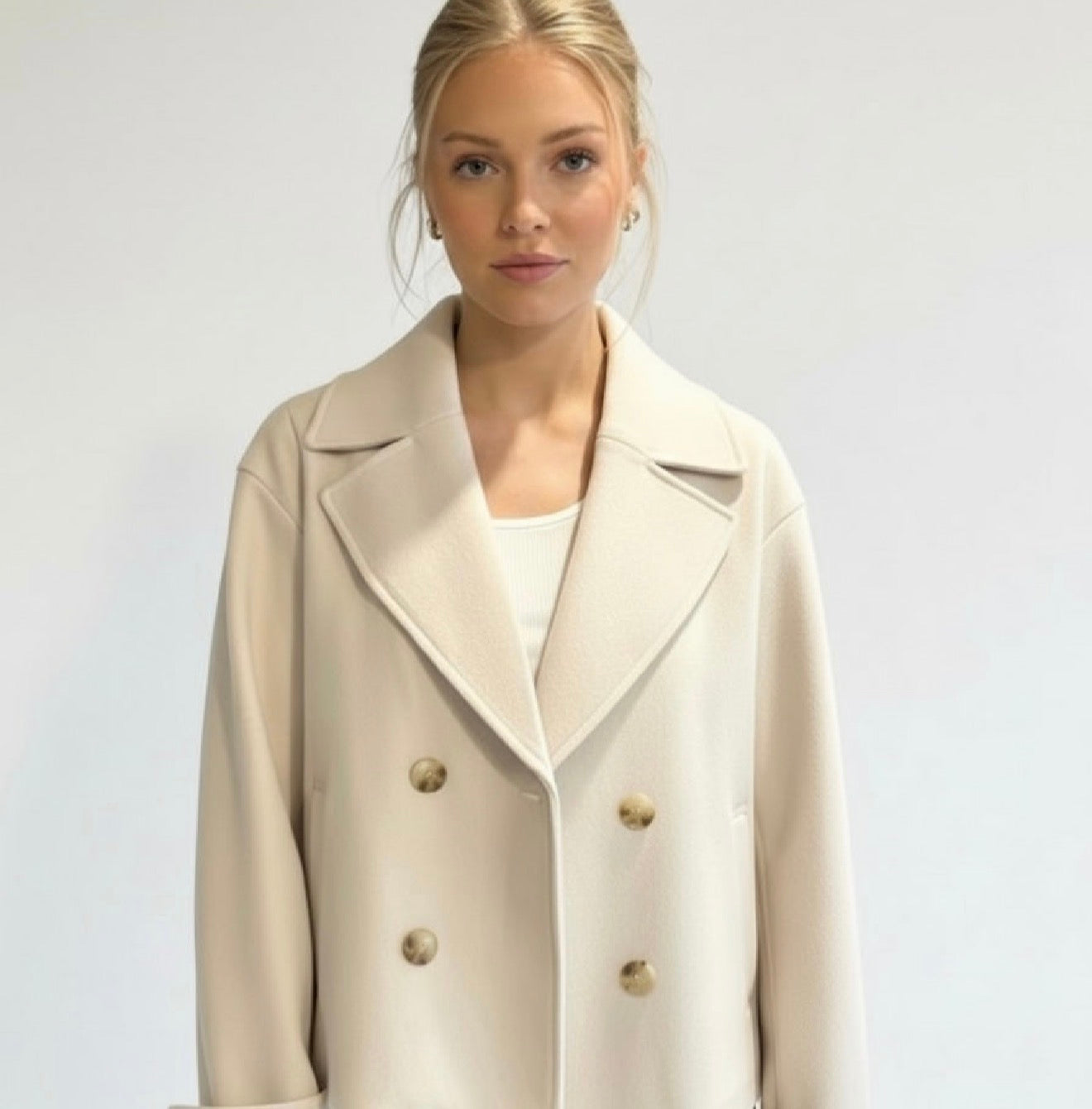 Wool Blend Double-Breasted Trench Coat for women. Features wide lapels, double front button fastening and structured tailoring. Ideal outerwear for autumn and winter layering with a refined, minimalist fit.