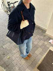 Wool Blend Double-Breasted Trench Coat for women. Features wide lapels, double front button fastening and structured tailoring. Ideal outerwear for autumn and winter layering with a refined, minimalist fit.